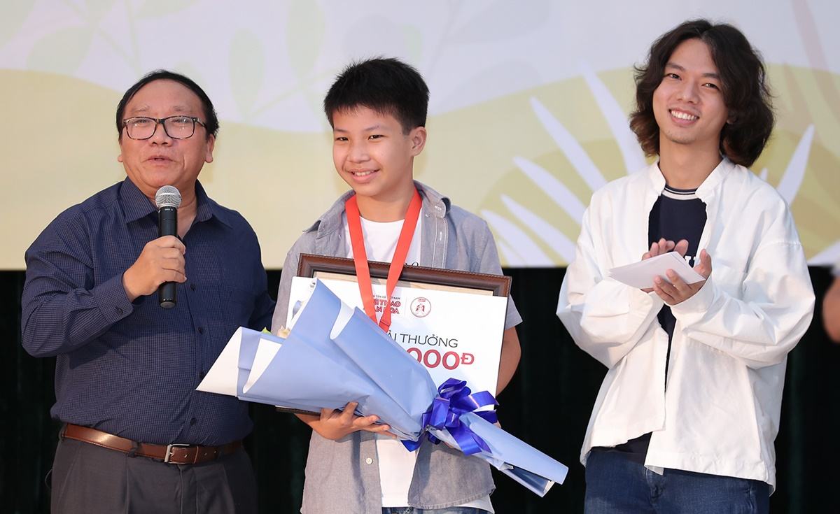Nhà thơ Trần Đăng Khoa (trái) trao giải cho bé Cao Khải An (12 tuổi, giữa). Ảnh: Hòa Nguyễn.
